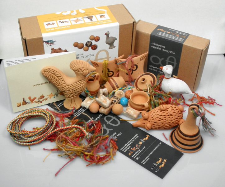 Ancient toys in a box animal figurines, bell-shaped rattle, spin-top, marbles and knucklebones