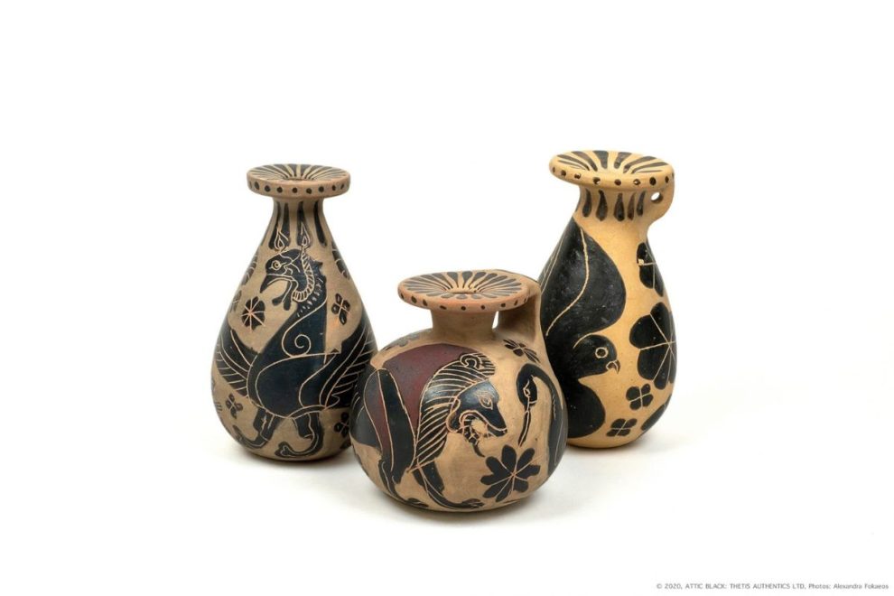 Three decorative ceramic vases with black-figure designs featuring animals and floral patterns, displayed against a plain background.