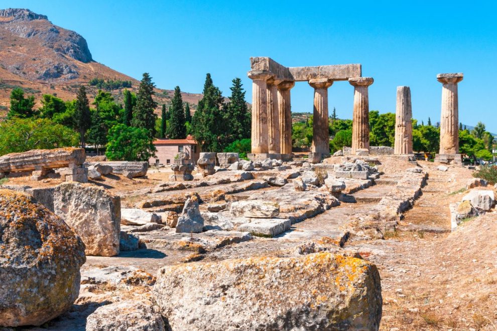 Ancient Corinth archaeological site with ruins and Doric temple columns in Greece.