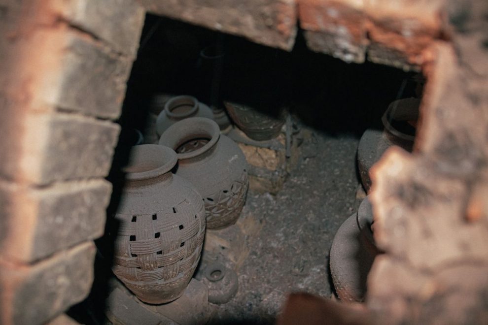 Traditional clay vessels inside an ancient pottery kiln during the firing process. 